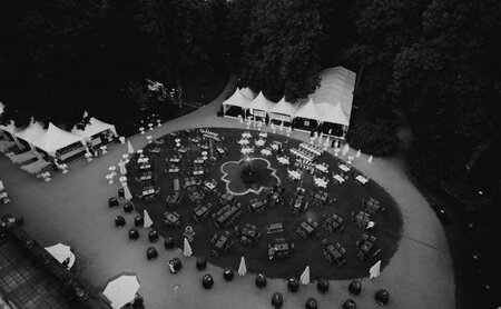 Ein Catering-Event mit runder Anordnung der Tische und weißen Zelten im Freien.
