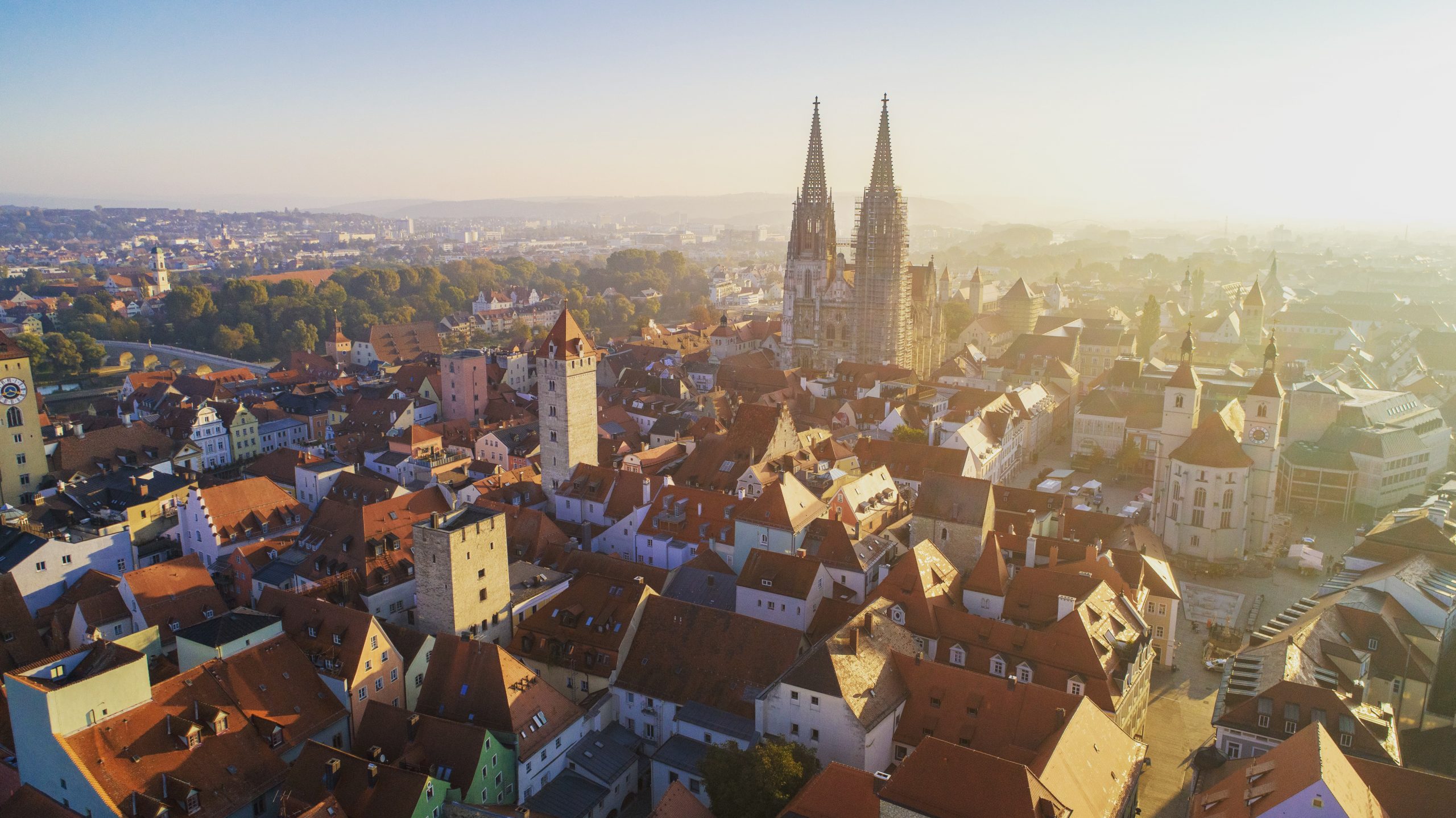 Blick auf die Dächerlandschaft von Regensburg mit Kirche und Abendstimmung.