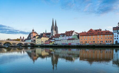 Donau am Tag mit Brücke und den bunten Hausfassaden am Ufer.